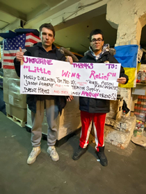 Two Foundation members holding up a sign thanking Little Wing Relief and some of our sponsors 
