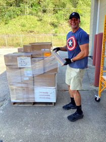 Image of volunteer Tristan Medley wrapping a pallet for shipment